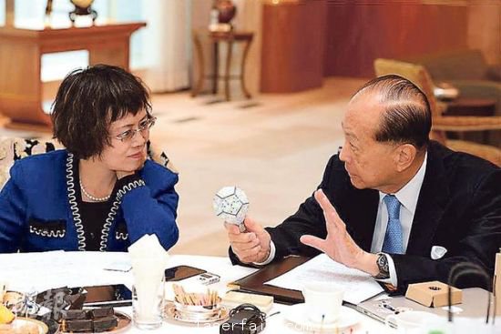 李嘉誠（右）在接受媒體訪問時指出，長實集團以香港為基地，常常積極在港尋找投資機會，但是政府很多政策，需時消化。圖為他向財新傳媒總編輯胡舒立介紹他本周的“最愛”納米LED燈泡。圖片來源：香港明報